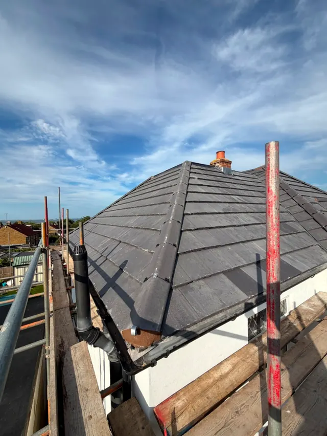 A finished hipped slate roof seen from the scaffold